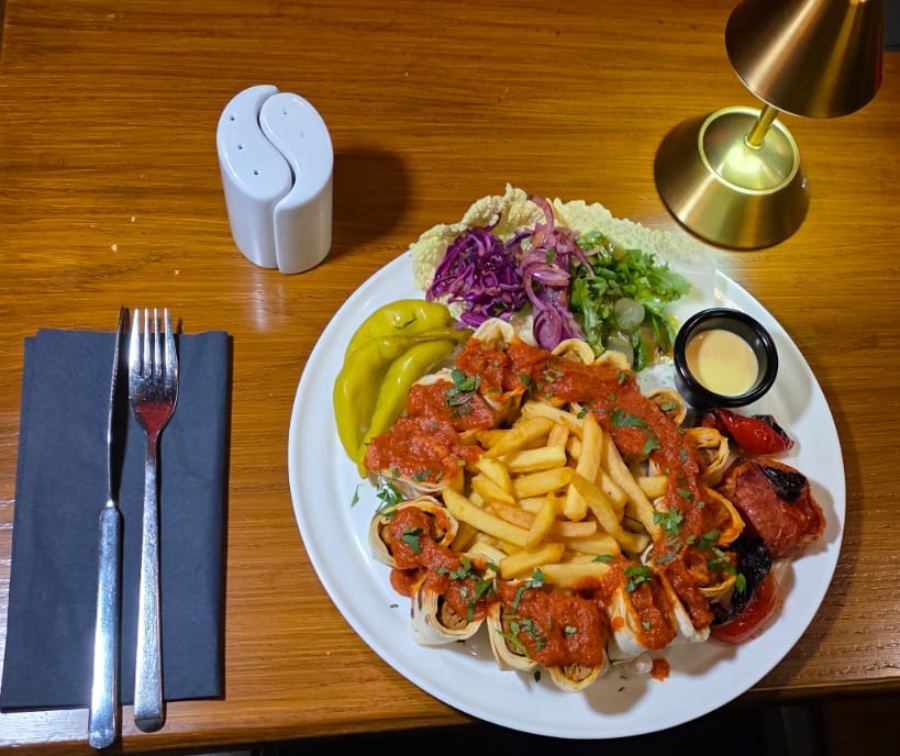 Ziba Restaurant’s plated Persian-style meal featuring wraps topped with tomato sauce, a serving 
of fries in Dunfermline.